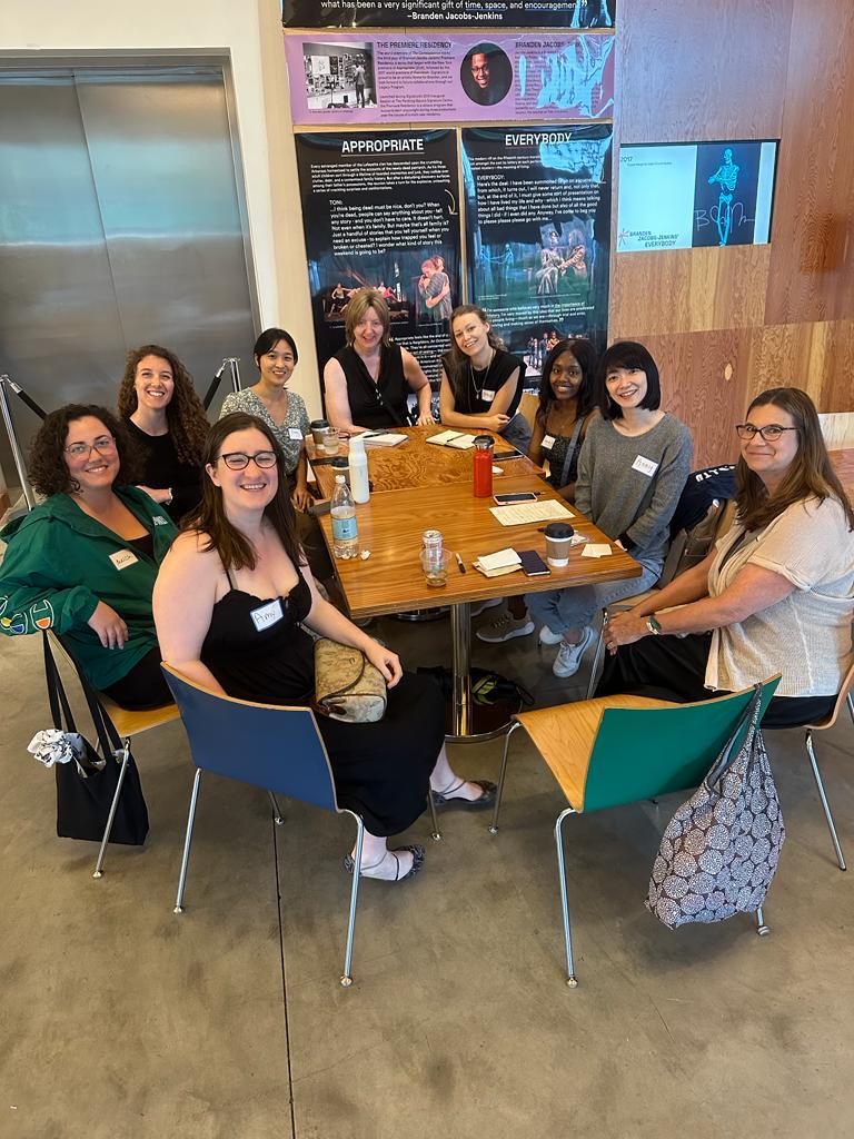 9 NYC Women in STEM members gathered around a table for a book club